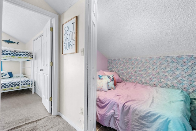 carpeted bedroom featuring a textured ceiling and lofted ceiling