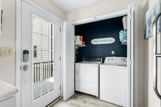 clothes washing area with light wood-type flooring and washer and clothes dryer