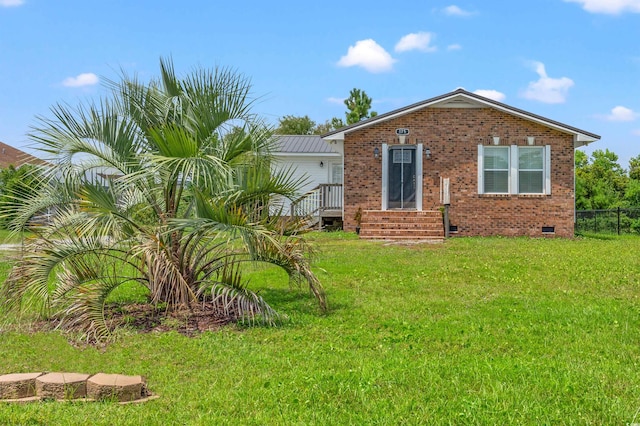 view of front of property with crawl space, brick siding, fence, and a front yard