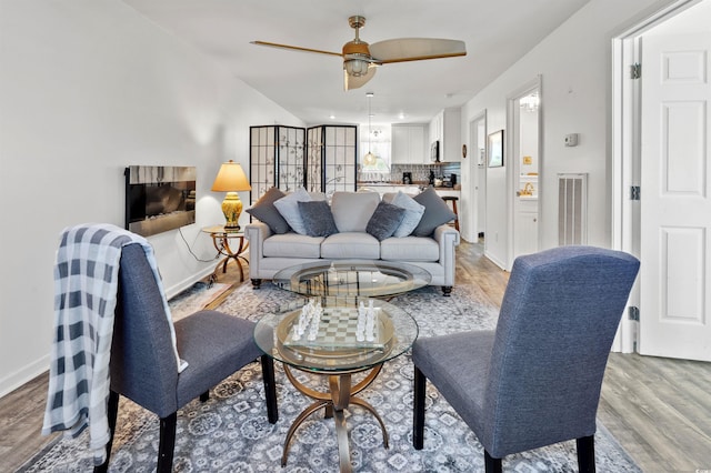 living room with ceiling fan and light wood-type flooring