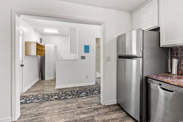 kitchen with appliances with stainless steel finishes, light hardwood / wood-style flooring, and white cabinets