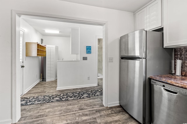 kitchen featuring stainless steel appliances, white cabinets, baseboards, and wood finished floors