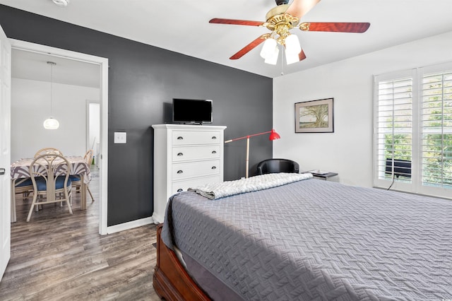 bedroom featuring ceiling fan, baseboards, and wood finished floors