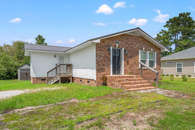 view of front facade featuring a front yard and a shed