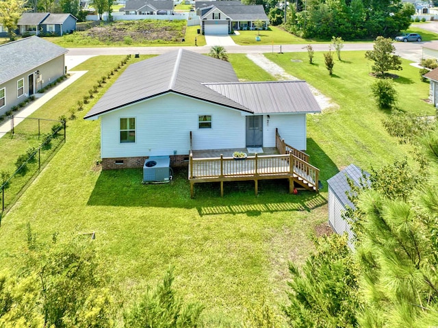 back of property with a yard, crawl space, fence, a deck, and metal roof