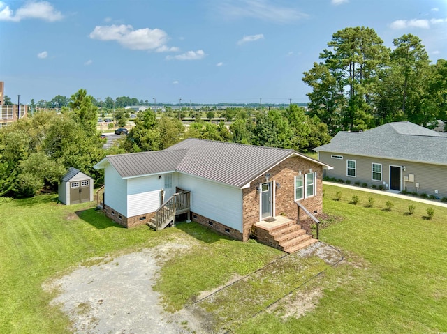 ranch-style house with driveway, an outbuilding, crawl space, a shed, and a front lawn