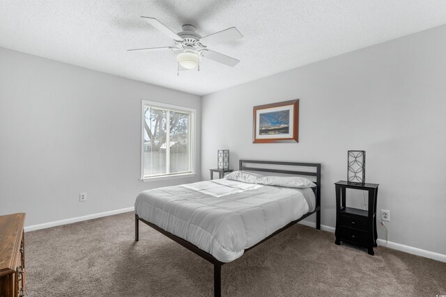 bedroom featuring dark colored carpet, a textured ceiling, and ceiling fan