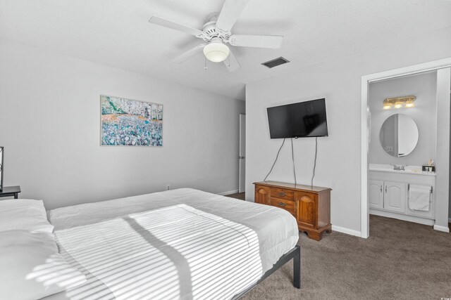 carpeted bedroom with connected bathroom, sink, and ceiling fan