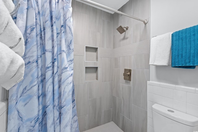 bathroom with tile walls, a shower with curtain, and toilet