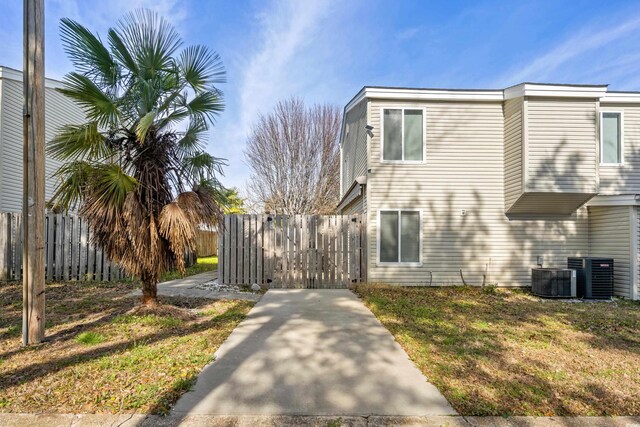 view of property exterior featuring central AC and a lawn