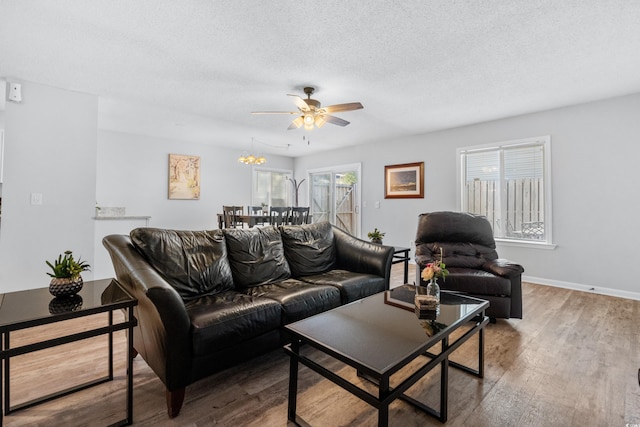 living room with hardwood / wood-style floors, a textured ceiling, and ceiling fan