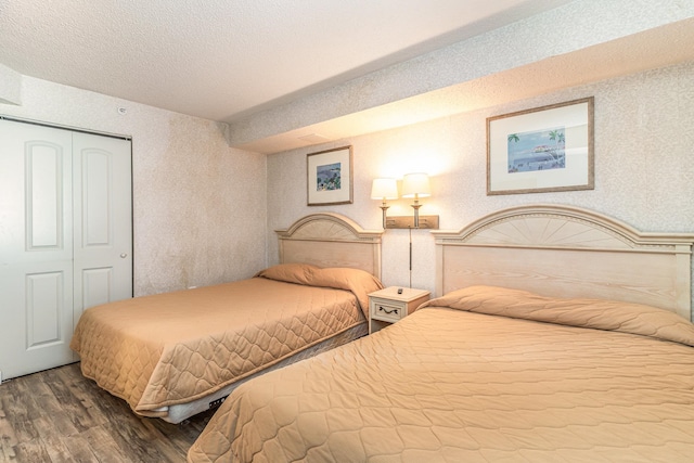 bedroom featuring a textured ceiling, a closet, and hardwood / wood-style flooring