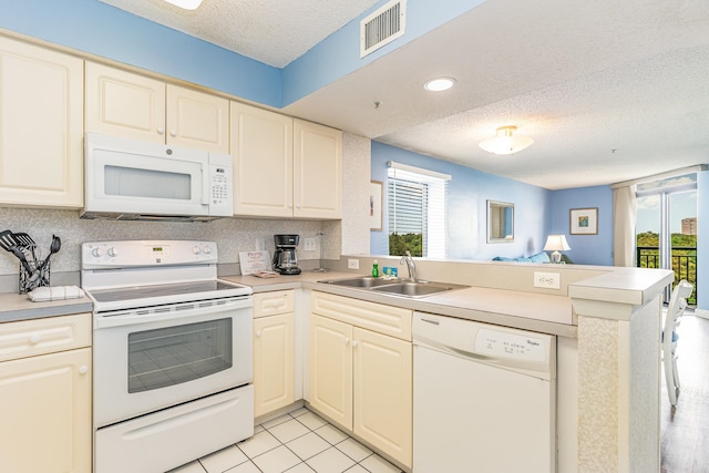 kitchen featuring white appliances, a wealth of natural light, and kitchen peninsula