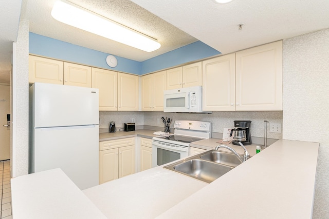 kitchen with a textured ceiling, white appliances, and sink