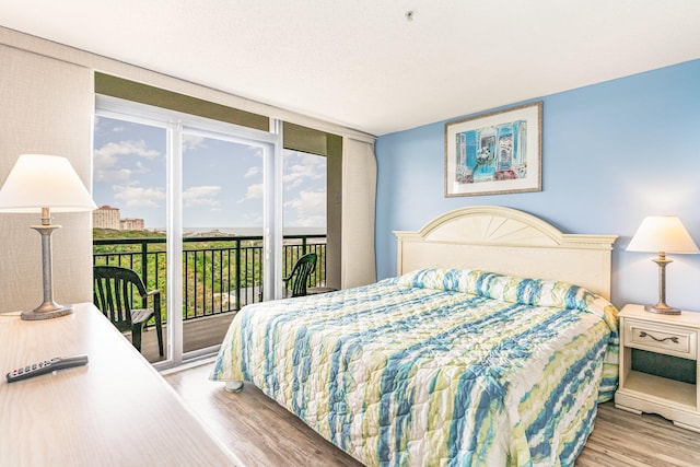 bedroom with access to exterior and light hardwood / wood-style flooring