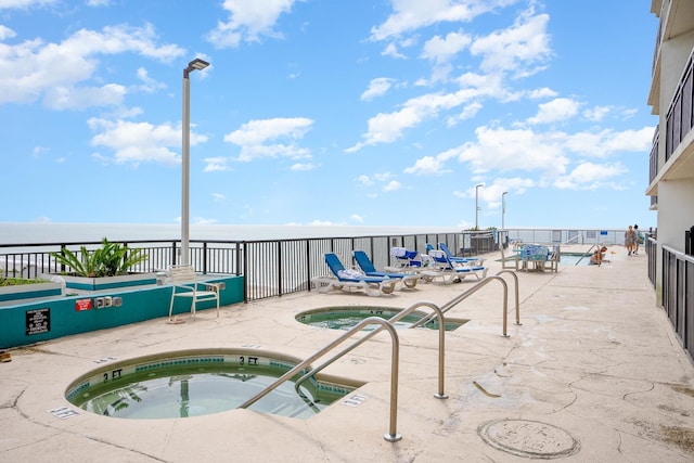 view of swimming pool featuring a hot tub