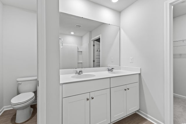 bathroom featuring wood-type flooring, vanity, and toilet