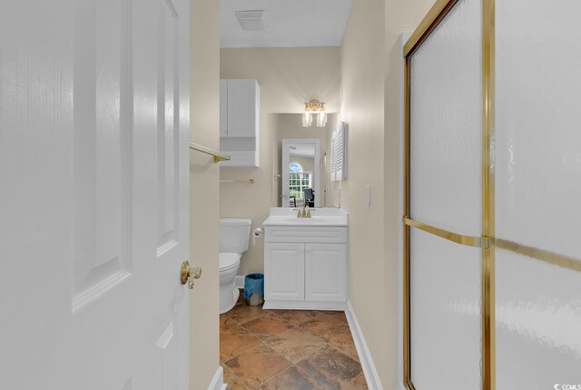 4709 Wild Iris Dr Unit 104, Myrtle Beach, SC 29577 - bathroom with toilet, an enclosed shower, vanity, stone finish flooring, and baseboards