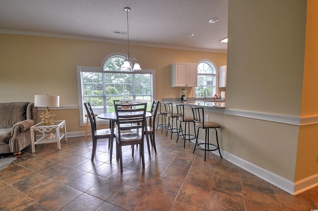 dining area featuring a textured ceiling, baseboards, a chandelier, and crown molding