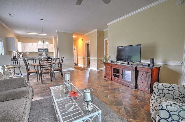 living area featuring baseboards, visible vents, ornamental molding, a textured ceiling, and ceiling fan with notable chandelier