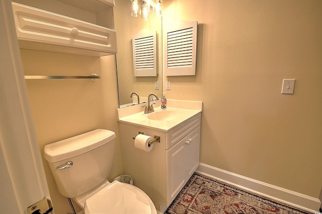 bathroom featuring visible vents, toilet, vanity, and baseboards