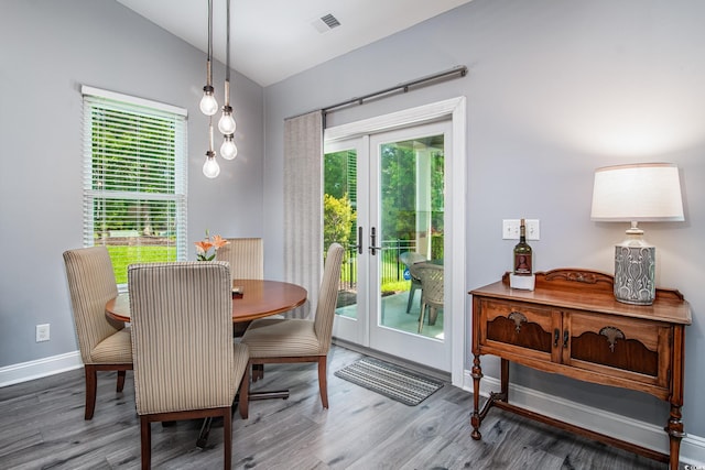 dining area with french doors, vaulted ceiling, hardwood / wood-style floors, and a wealth of natural light