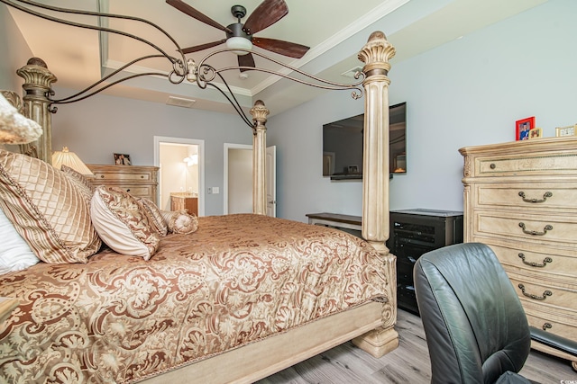 bedroom featuring connected bathroom, light hardwood / wood-style flooring, and ornamental molding