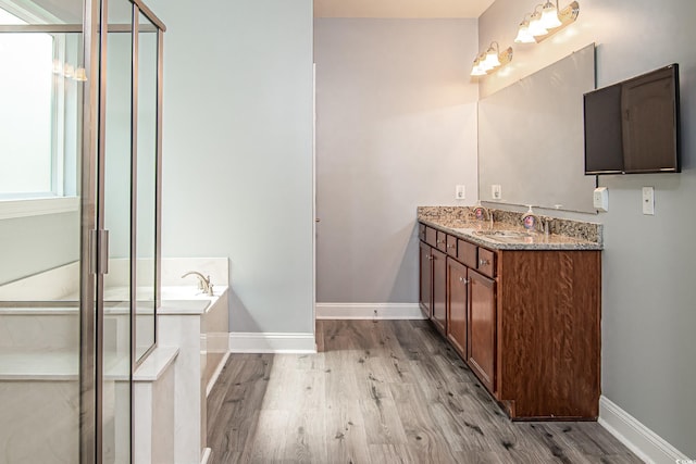 bathroom featuring vanity, hardwood / wood-style floors, and plus walk in shower