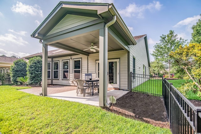 back of property with a yard, ceiling fan, and a patio area