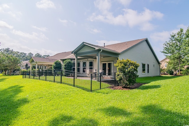 back of house with french doors, ceiling fan, and a yard