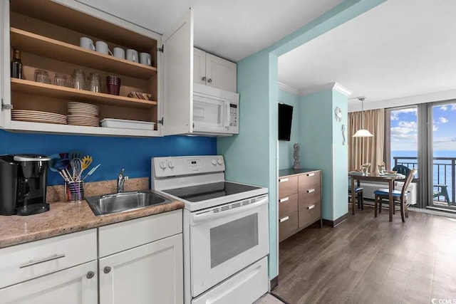 kitchen with white appliances, hanging light fixtures, wood-type flooring, sink, and white cabinetry