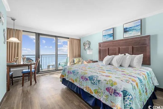 bedroom with wood-type flooring, a water view, and access to outside