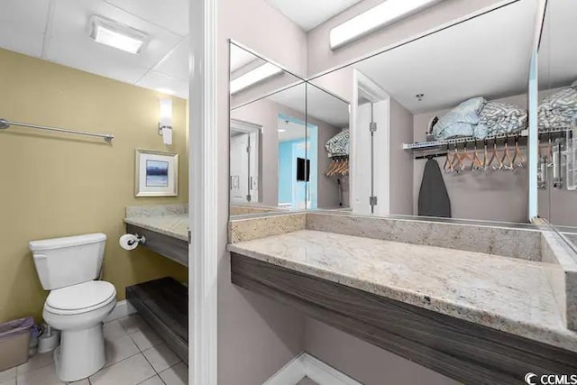 bathroom featuring toilet, vanity, and tile patterned flooring