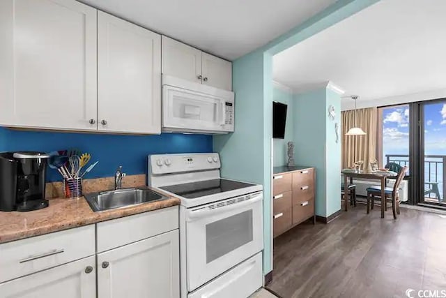 kitchen featuring white cabinets, hardwood / wood-style flooring, decorative light fixtures, white appliances, and sink