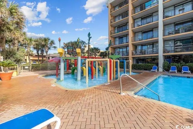 view of pool with a playground and a patio area