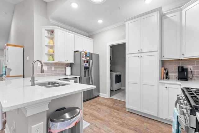 kitchen with backsplash, white cabinets, stainless steel appliances, and light hardwood / wood-style floors