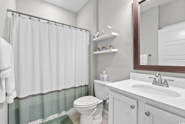 bathroom featuring tile patterned floors, vanity, and toilet