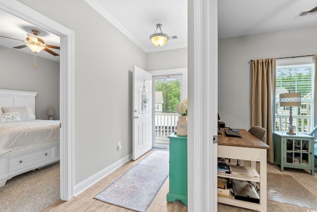 interior space featuring ceiling fan, plenty of natural light, light carpet, and ornamental molding