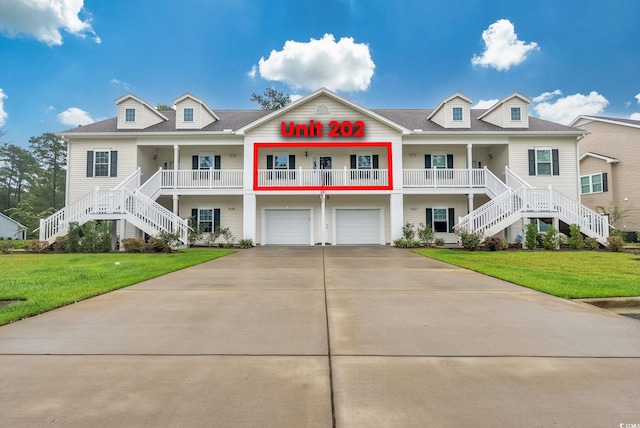 view of front of house featuring a front yard, covered porch, and a garage