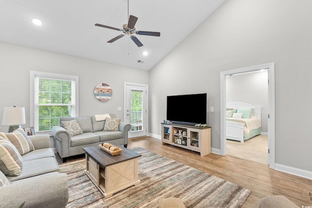 living room featuring ceiling fan, light hardwood / wood-style flooring, and high vaulted ceiling