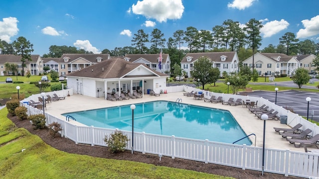 view of swimming pool featuring a patio and a yard