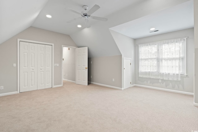 additional living space with light carpet, vaulted ceiling, and ceiling fan