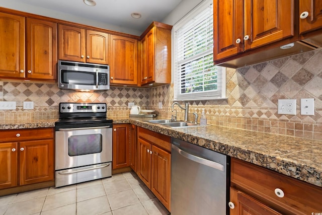 kitchen with appliances with stainless steel finishes, backsplash, crown molding, and light tile patterned flooring