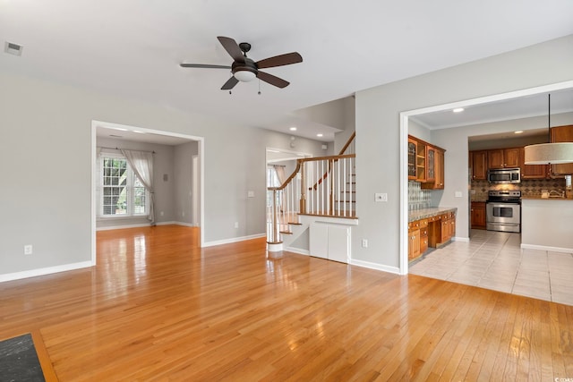 unfurnished living room with ceiling fan and light hardwood / wood-style floors