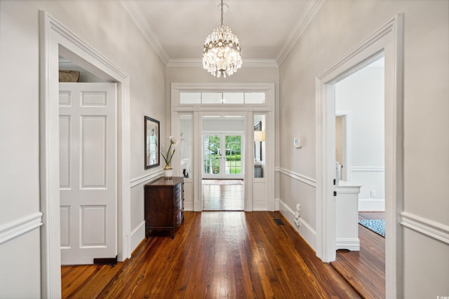 entrance foyer with ornamental molding, dark hardwood / wood-style floors, and a chandelier