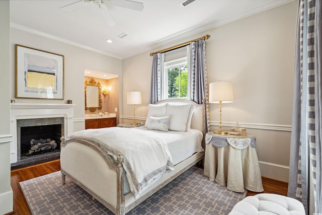 bedroom with ornamental molding, dark wood-type flooring, ceiling fan, and a high end fireplace