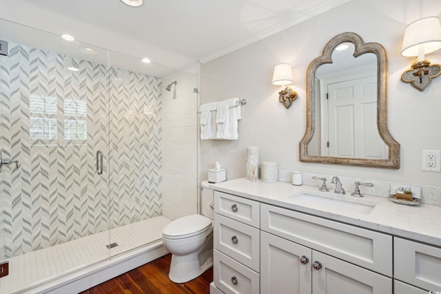 bathroom featuring hardwood / wood-style flooring, toilet, an enclosed shower, vanity, and ornamental molding