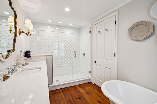 bathroom featuring shower with separate bathtub, vanity, hardwood / wood-style floors, and crown molding