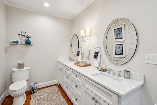 bathroom with crown molding, hardwood / wood-style flooring, double vanity, and toilet