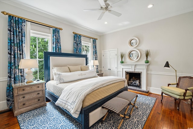 bedroom featuring ceiling fan, crown molding, a closet, and hardwood / wood-style flooring